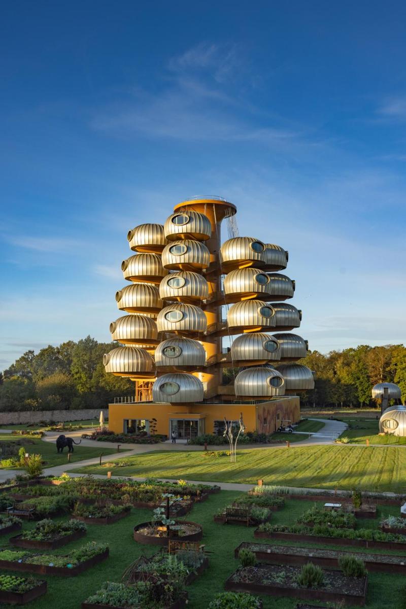 un bâtiment circulaire avec un jardin devant lui dans l'établissement L'EssenCiel, à Piré-sur-Seiche