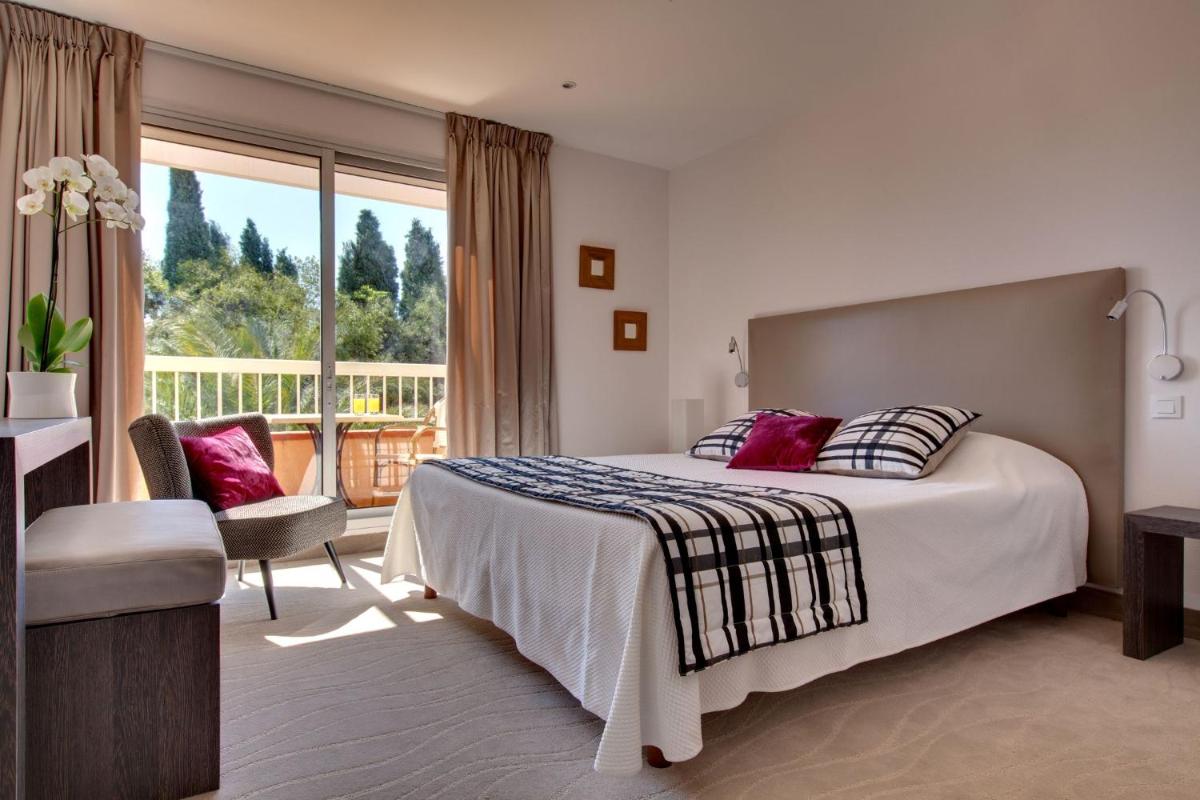 une chambre d'hôtel avec un lit et un balcon dans l'établissement Le Cottage - Hotel & Spa, à Argelès-sur-Mer
