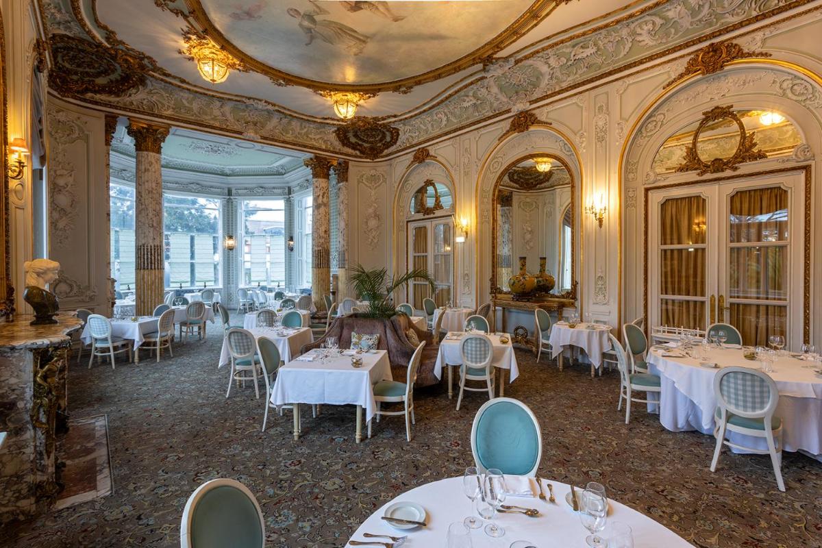 um restaurante com mesas e cadeiras em uma sala em Pestana Palace Lisboa Hotel & National Monument - The Leading Hotels of the World em Lisboa