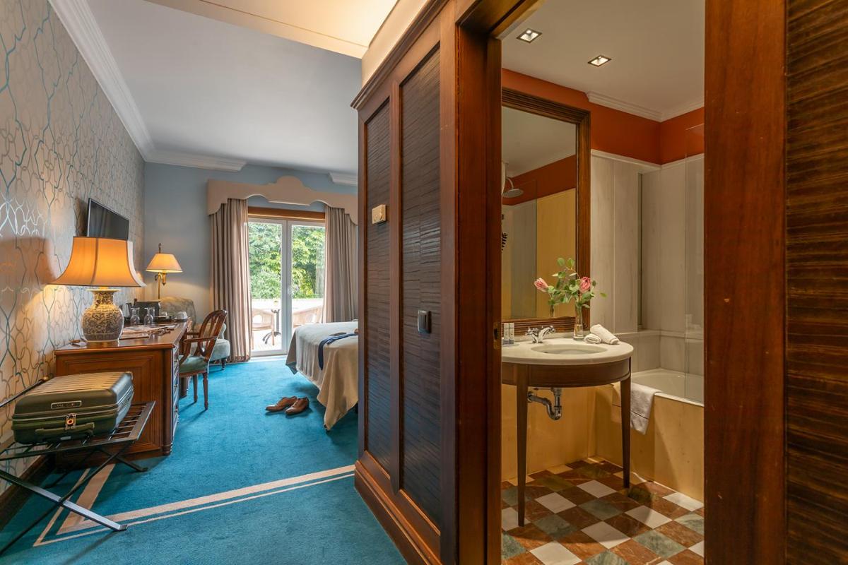 um quarto de hotel com uma casa de banho com uma cama e um lavatório em Pestana Palace Lisboa Hotel & National Monument - The Leading Hotels of the World em Lisboa