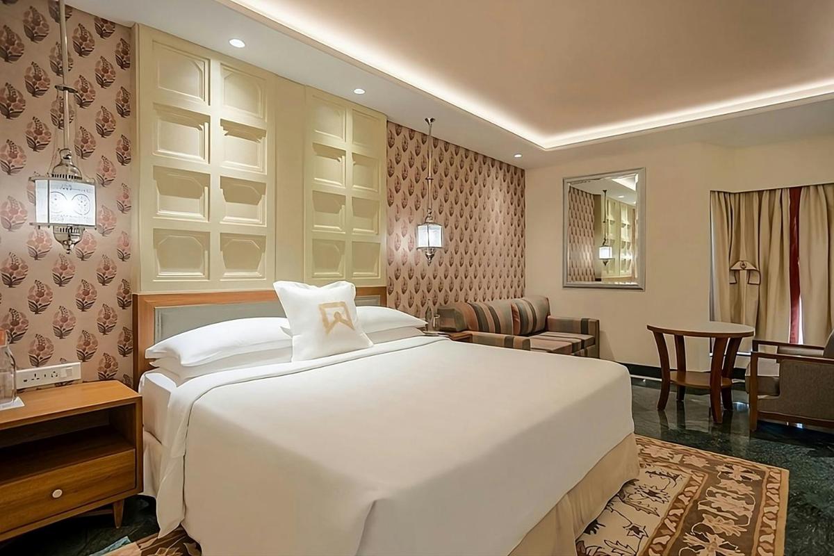 a bedroom with a large white bed in a room at ITC Mughal, A Luxury Collection Resort & Spa, Agra in Agra