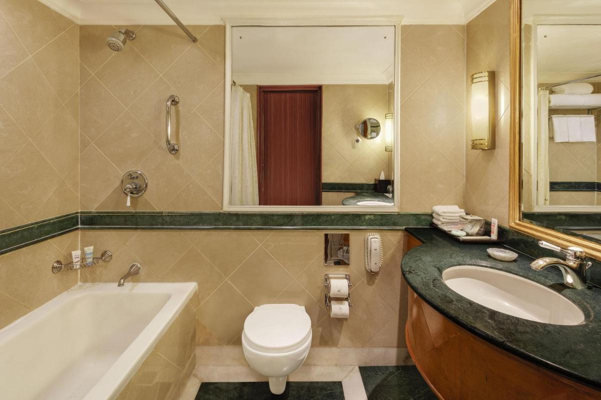 a bathroom with a tub and a toilet and a sink at ITC Mughal, A Luxury Collection Resort & Spa, Agra in Agra