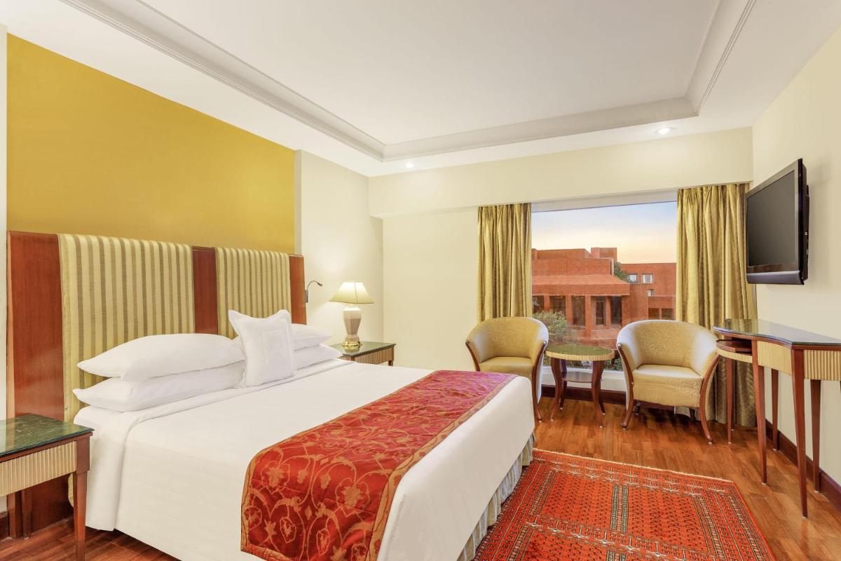 a hotel room with a large bed and a desk at ITC Mughal, A Luxury Collection Resort & Spa, Agra in Agra
