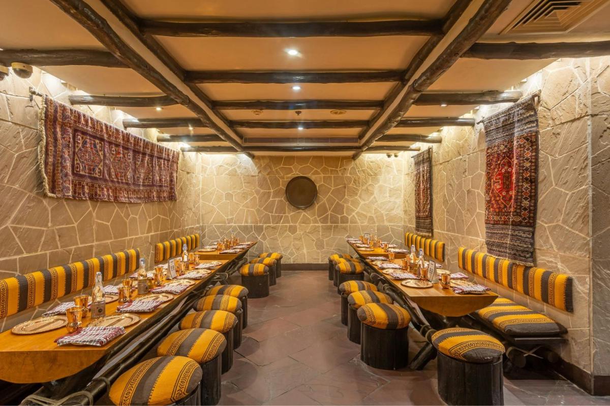 a restaurant with long tables and yellow chairs at ITC Mughal, A Luxury Collection Resort & Spa, Agra in Agra