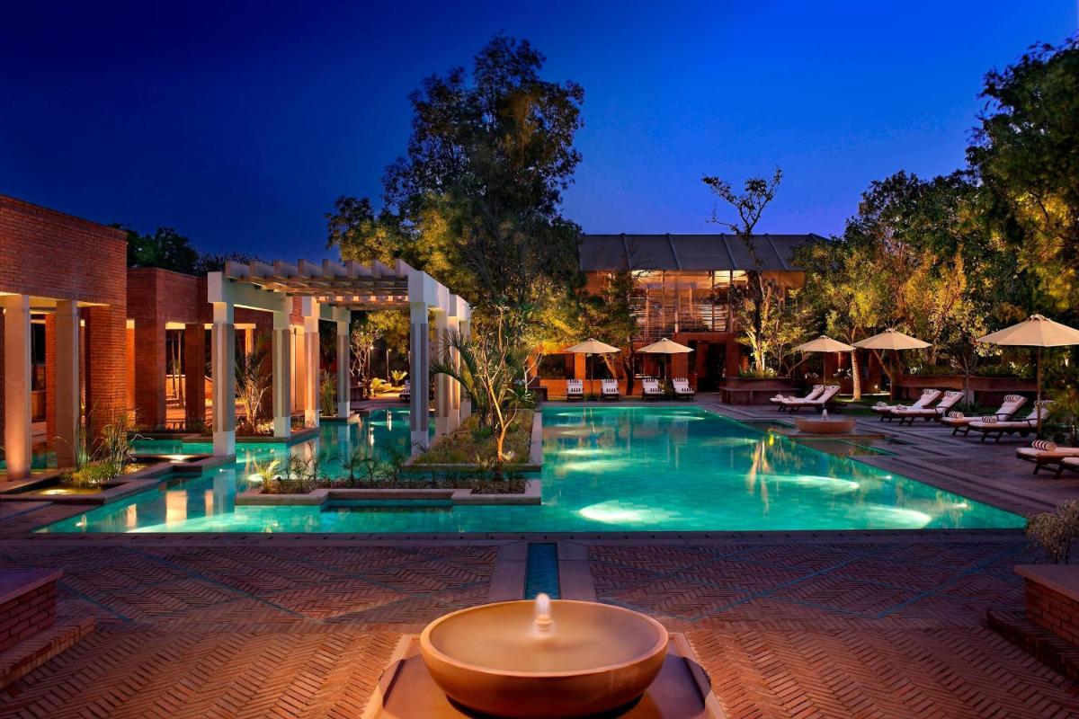a large swimming pool in a hotel at night at ITC Mughal, A Luxury Collection Resort & Spa, Agra in Agra