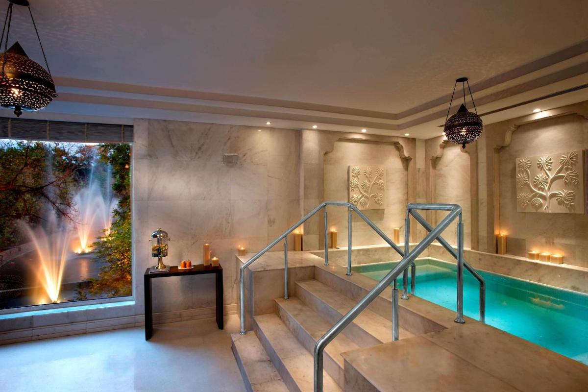 a swimming pool and a staircase in a building at ITC Mughal, A Luxury Collection Resort & Spa, Agra in Agra