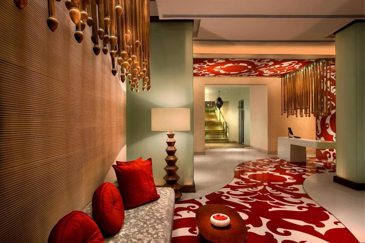 a room with a bed with red pillows at ITC Mughal, A Luxury Collection Resort & Spa, Agra in Agra