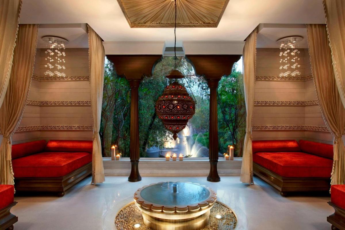 a living room with red couches and a large window at ITC Mughal, A Luxury Collection Resort & Spa, Agra in Agra
