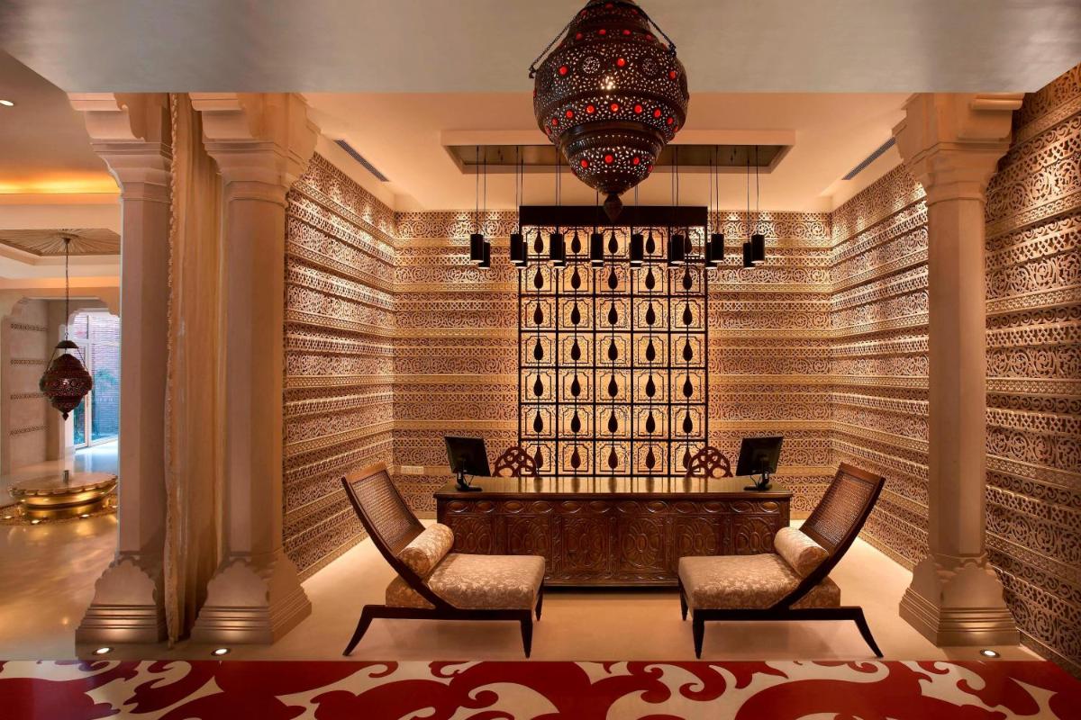 a court room with chairs and a wall of wine bottles at ITC Mughal, A Luxury Collection Resort & Spa, Agra in Agra