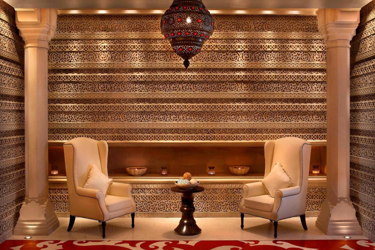 a lobby with two chairs and a table and a chandelier at ITC Mughal, A Luxury Collection Resort & Spa, Agra in Agra