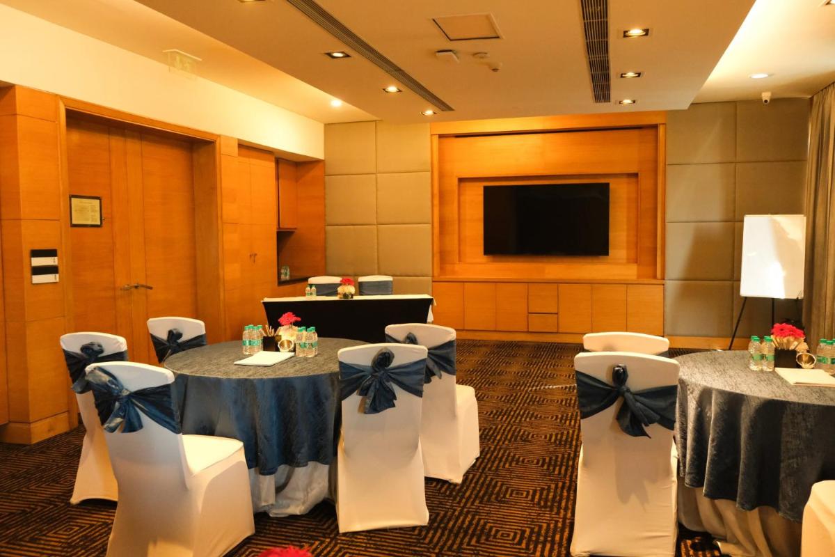 a conference room with tables and chairs and a flat screen tv at Crowne Plaza Today Gurugram by IHG in Gurgaon