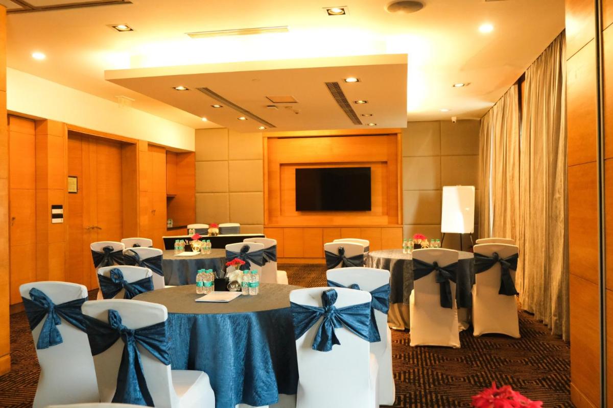 a conference room with tables and chairs with blue bows at Crowne Plaza Today Gurugram by IHG in Gurgaon