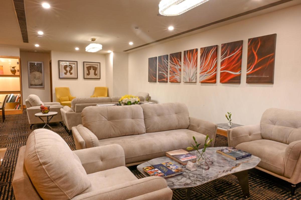 a living room with couches and tables and paintings at Crowne Plaza Today Gurugram by IHG in Gurgaon