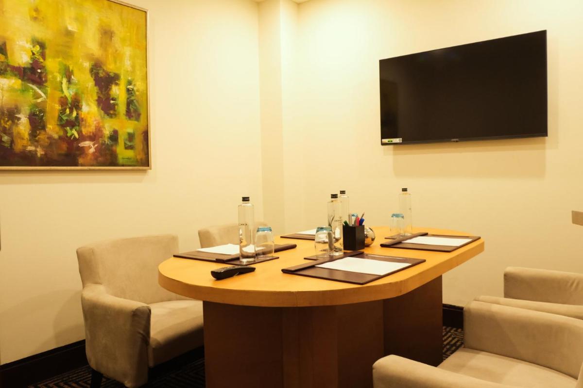 a room with a table with chairs and a flat screen tv at Crowne Plaza Today Gurugram by IHG in Gurgaon