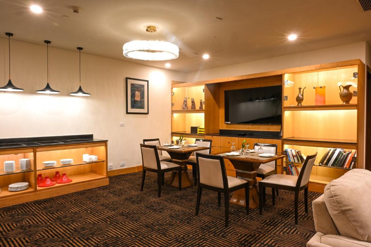 a dining room with tables and chairs and a couch at Crowne Plaza Today Gurugram by IHG in Gurgaon