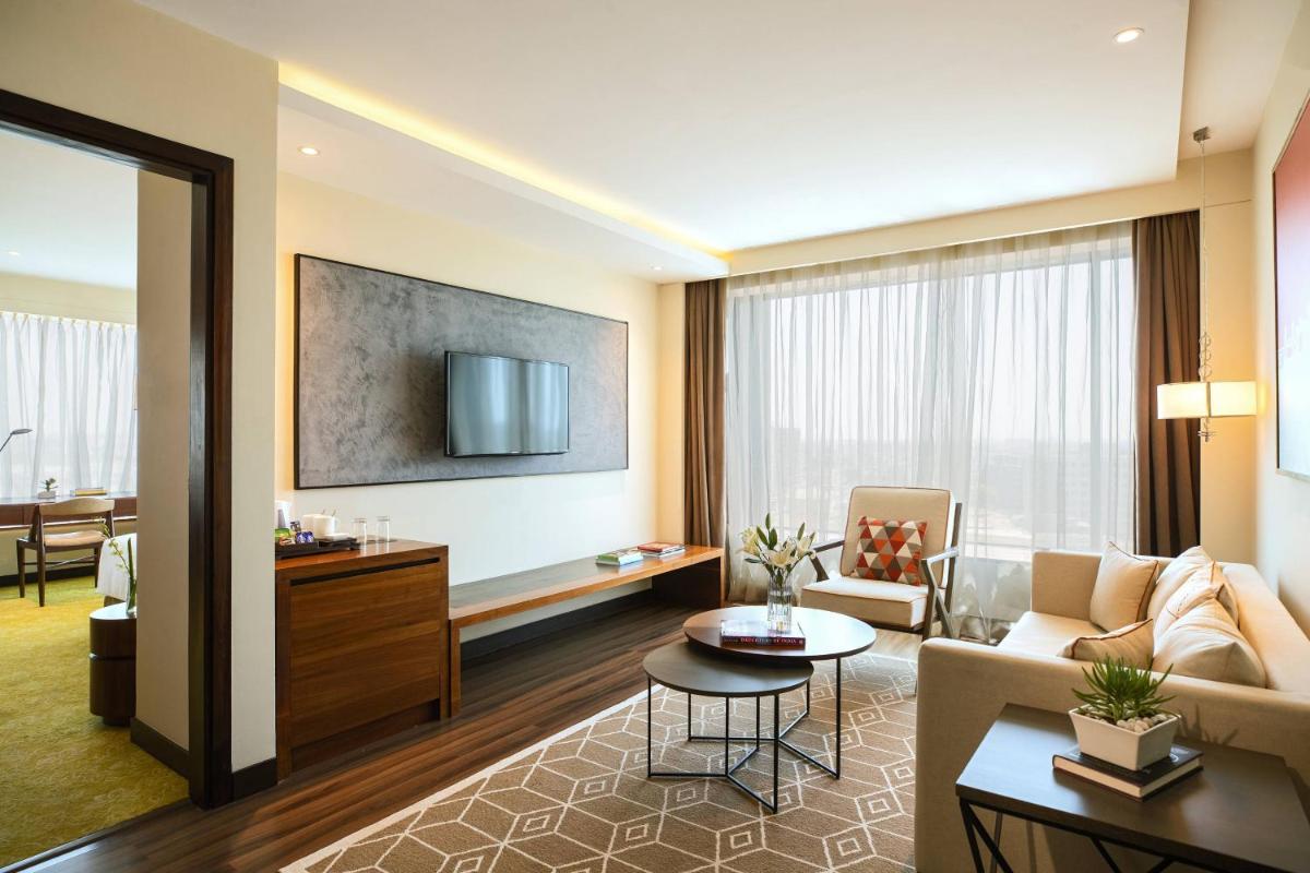 a living room with a couch and a table at Renaissance Ahmedabad Hotel in Ahmedabad
