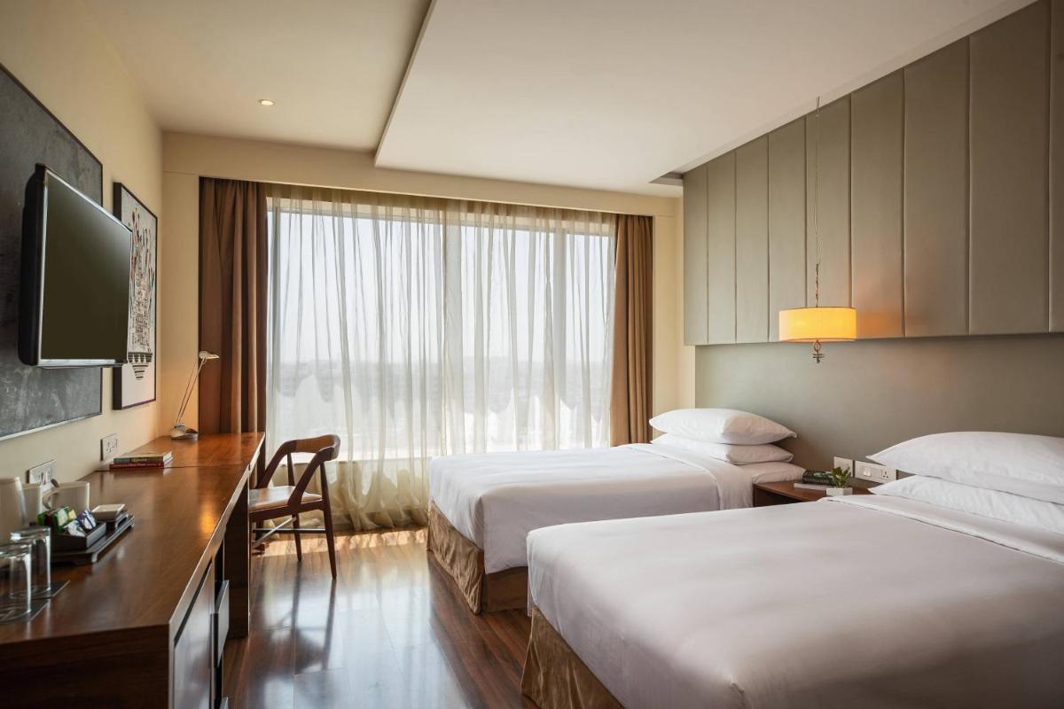 a hotel room with two beds and a television at Renaissance Ahmedabad Hotel in Ahmedabad