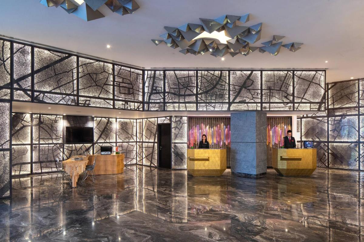 a lobby with a wall of mirrors and a chandelier at Renaissance Ahmedabad Hotel in Ahmedabad