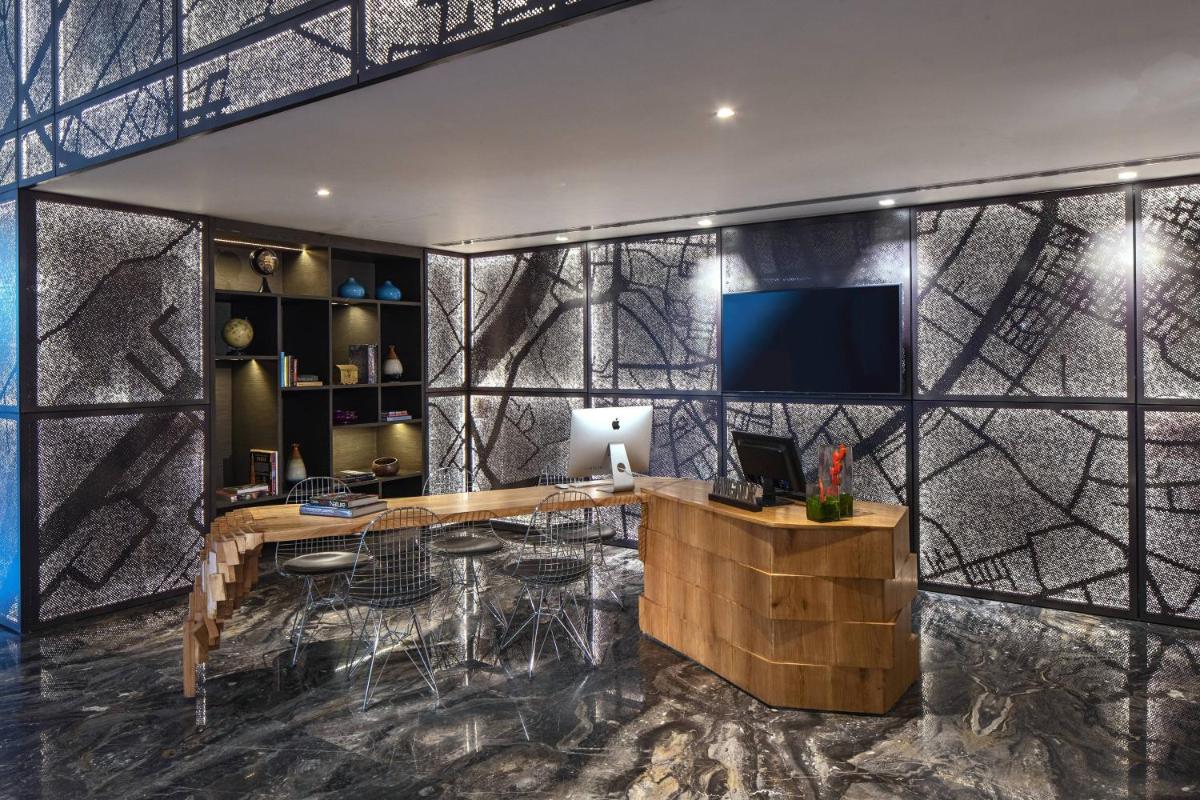 a room with a desk and a tv on a wall at Renaissance Ahmedabad Hotel in Ahmedabad