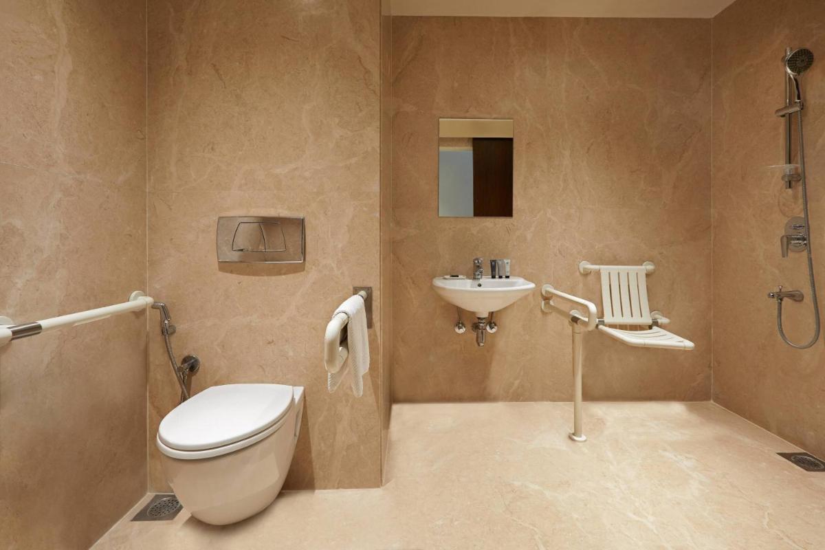 a bathroom with a toilet and a sink at Renaissance Ahmedabad Hotel in Ahmedabad