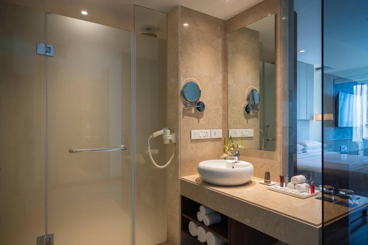 a bathroom with a sink and a glass shower at Renaissance Ahmedabad Hotel in Ahmedabad