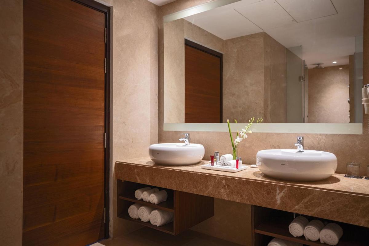 a bathroom with two sinks and a mirror at Renaissance Ahmedabad Hotel in Ahmedabad