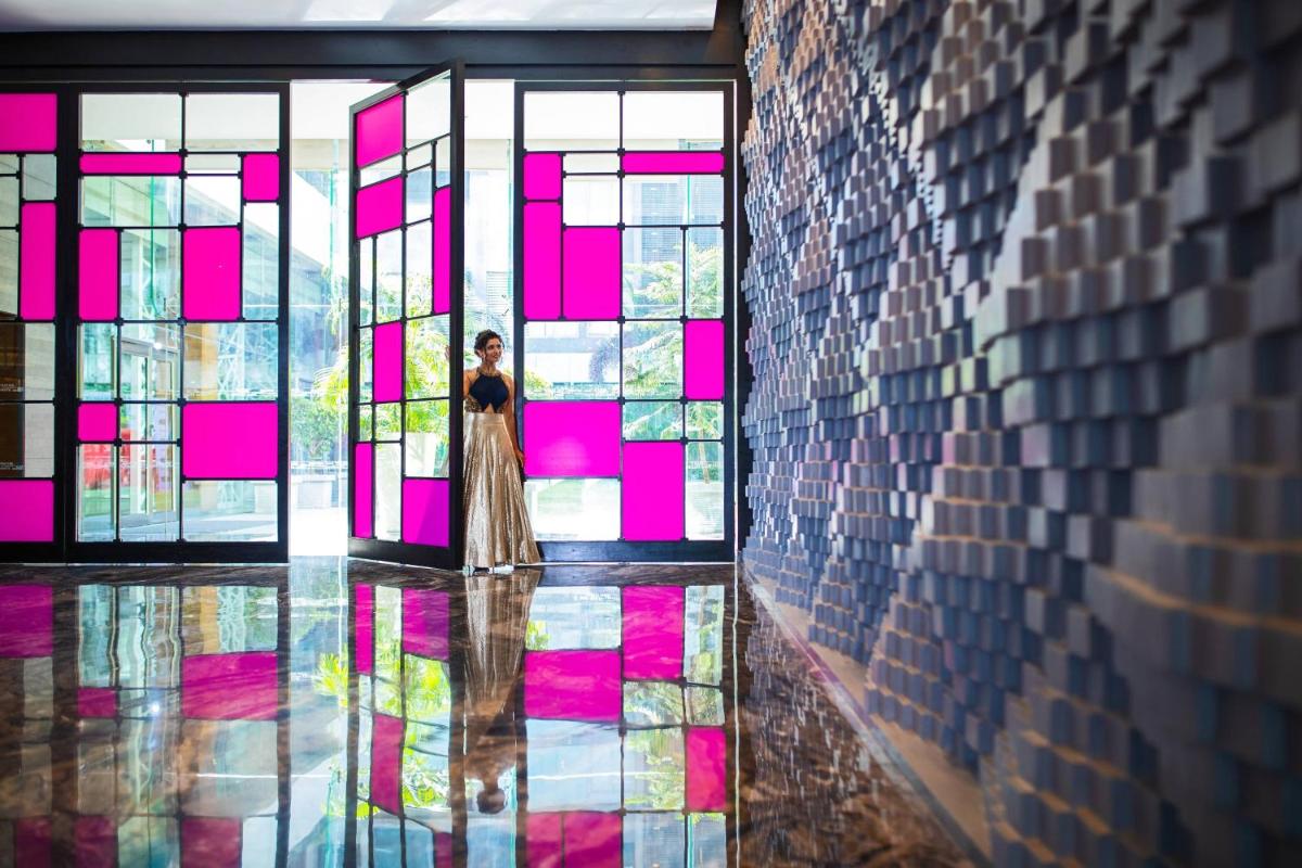 a woman standing in front of a stained glass window at Renaissance Ahmedabad Hotel in Ahmedabad