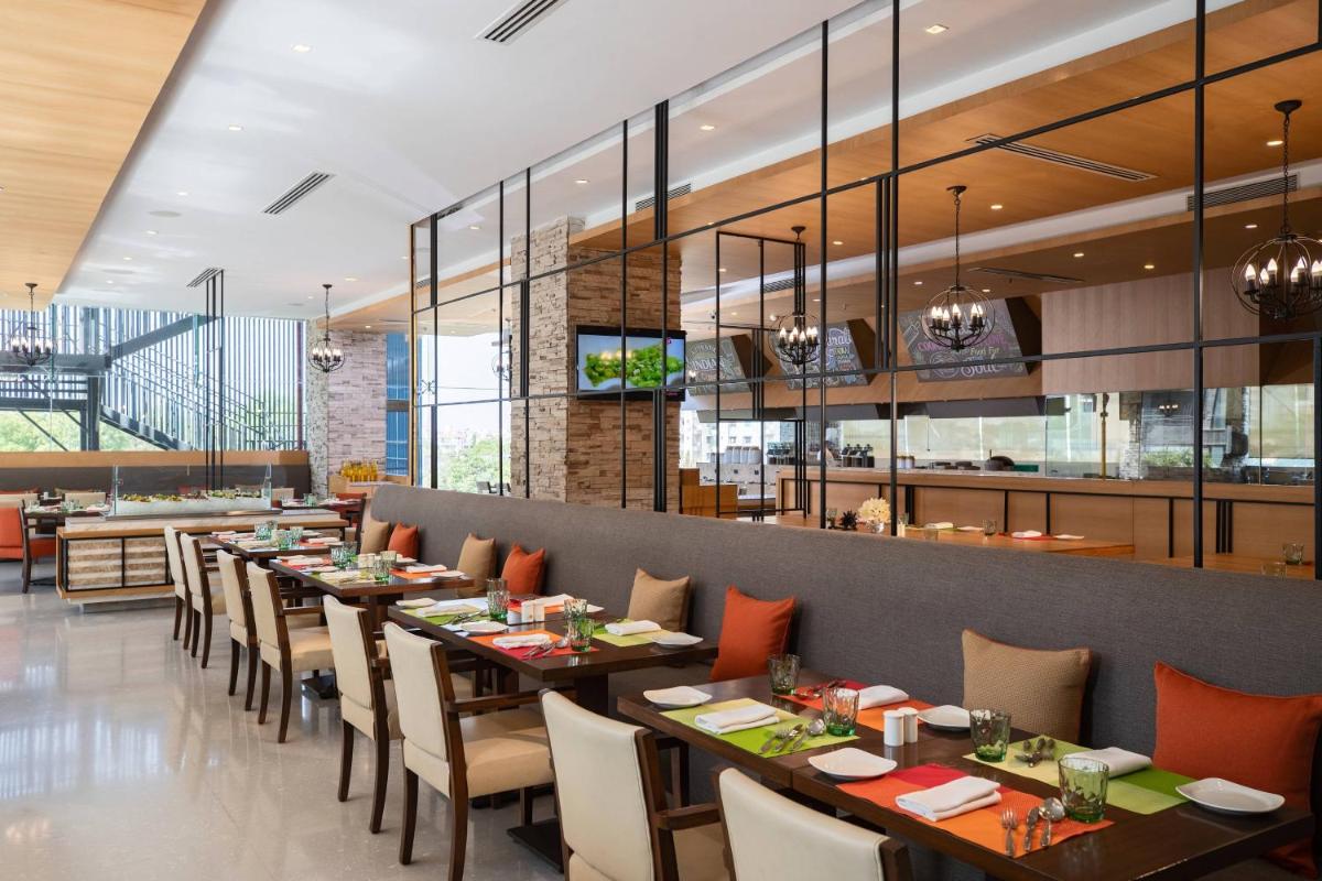 a dining room with long tables and chairs at Renaissance Ahmedabad Hotel in Ahmedabad