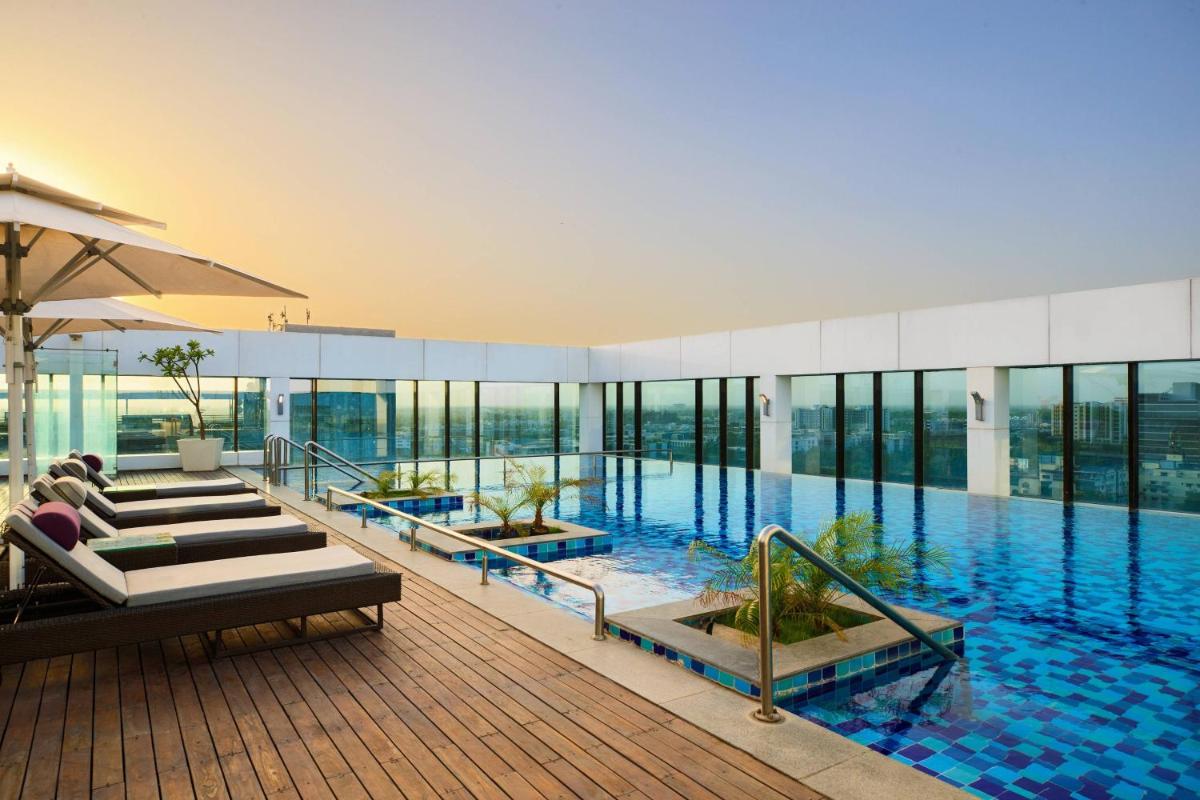 a large swimming pool in a building with windows at Renaissance Ahmedabad Hotel in Ahmedabad