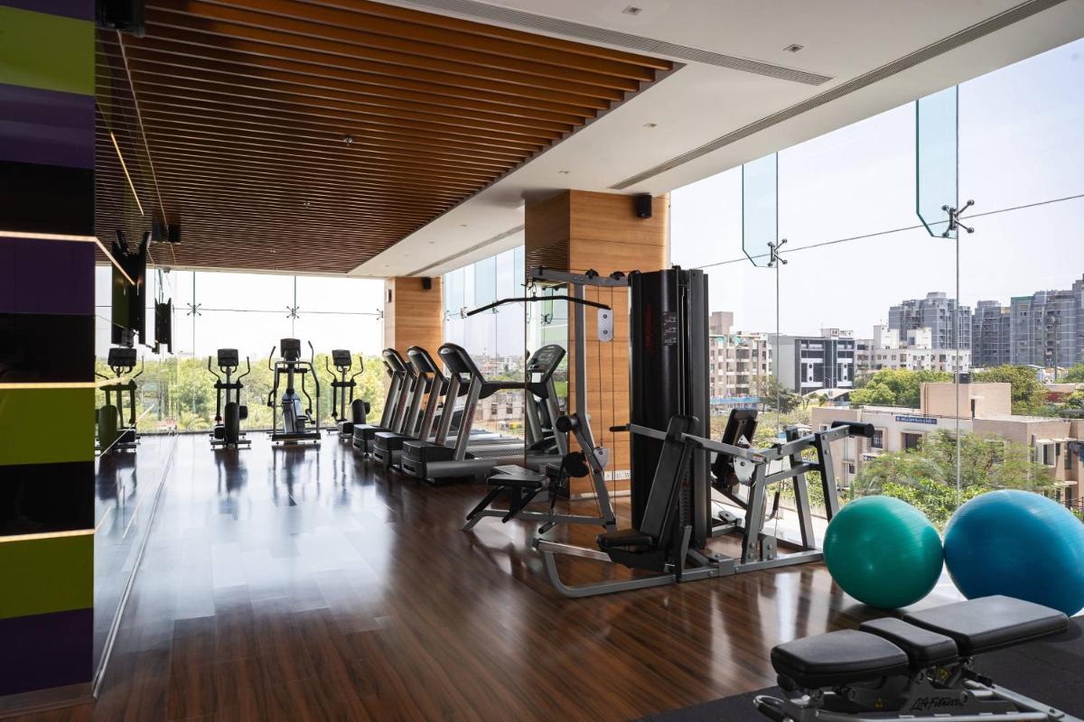 a gym with a bunch of exercise equipment in a building at Renaissance Ahmedabad Hotel in Ahmedabad