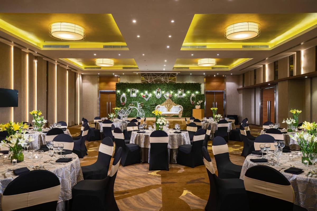 a banquet hall with round tables and chairs at Renaissance Ahmedabad Hotel in Ahmedabad