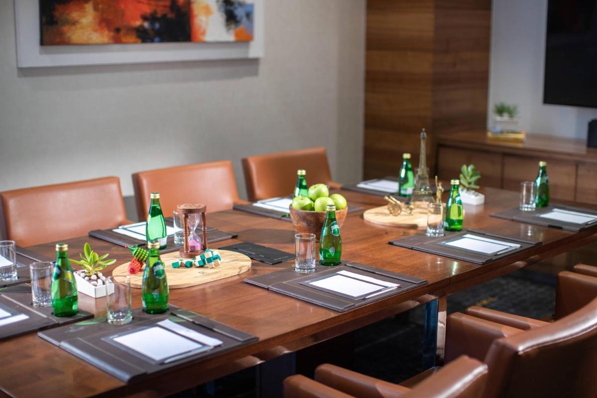 a long wooden table with bottles on top of it at Renaissance Ahmedabad Hotel in Ahmedabad