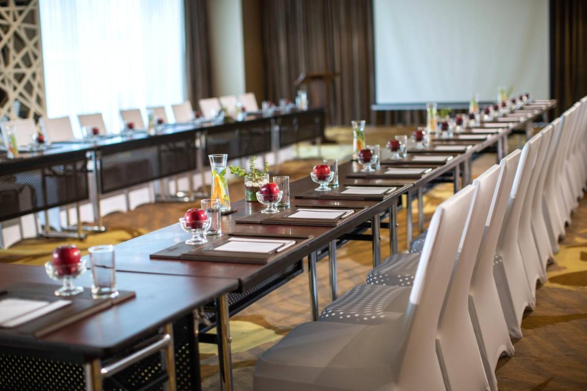 a row of tables and chairs in a room at Renaissance Ahmedabad Hotel in Ahmedabad