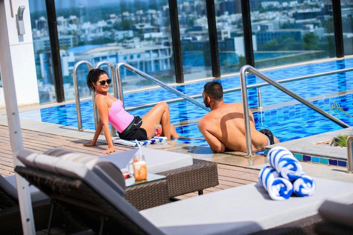 a man and woman sitting in a swimming pool at Renaissance Ahmedabad Hotel in Ahmedabad