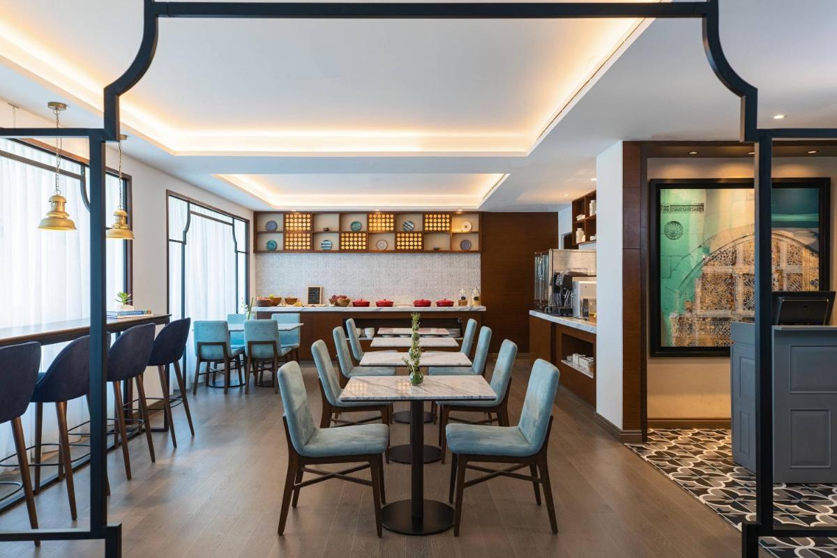 a dining room with a table and chairs at Renaissance Ahmedabad Hotel in Ahmedabad