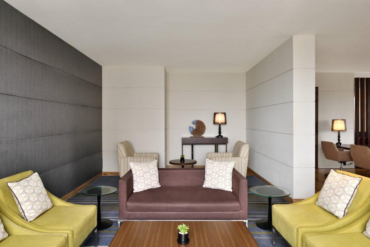 a waiting room with a couch and two chairs at Courtyard by Marriott Bengaluru Outer Ring Road in Bengaluru