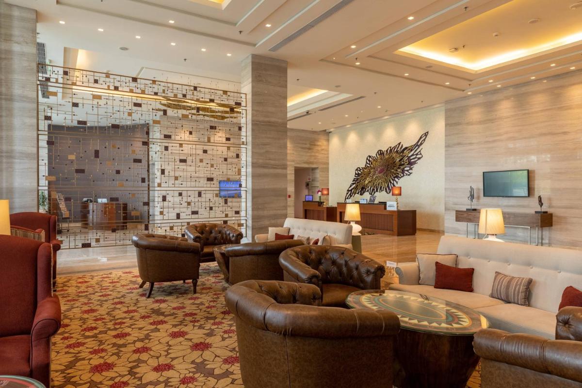 a lobby with leather couches and a waiting room at Courtyard by Marriott Bengaluru Outer Ring Road in Bengaluru