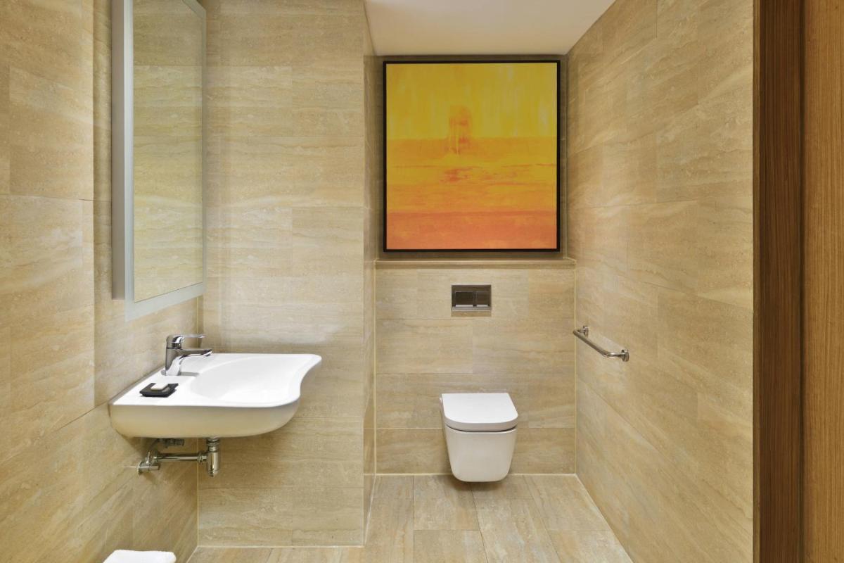 a bathroom with a sink and a toilet at Courtyard by Marriott Bengaluru Outer Ring Road in Bengaluru