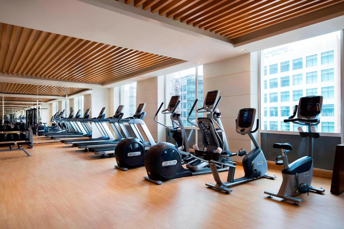 a gym with rows of exercise bikes and treadmills at Courtyard by Marriott Bengaluru Outer Ring Road in Bengaluru