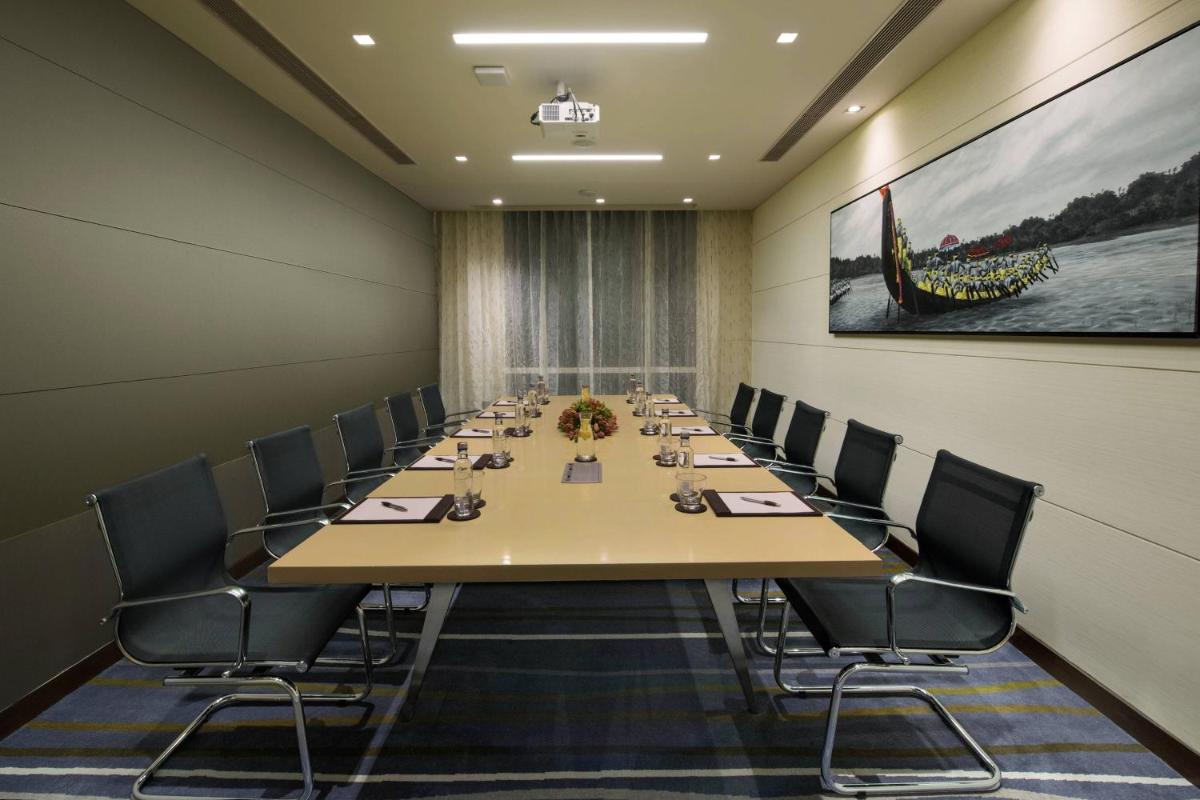 a conference room with a long table and chairs at Courtyard by Marriott Bengaluru Outer Ring Road in Bengaluru