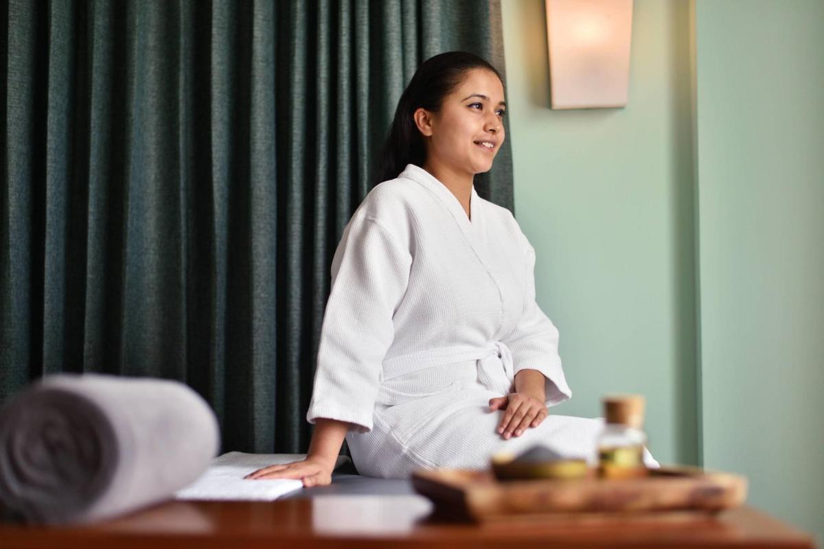 a woman in a robe sitting on a table at Courtyard by Marriott Bengaluru Outer Ring Road in Bengaluru