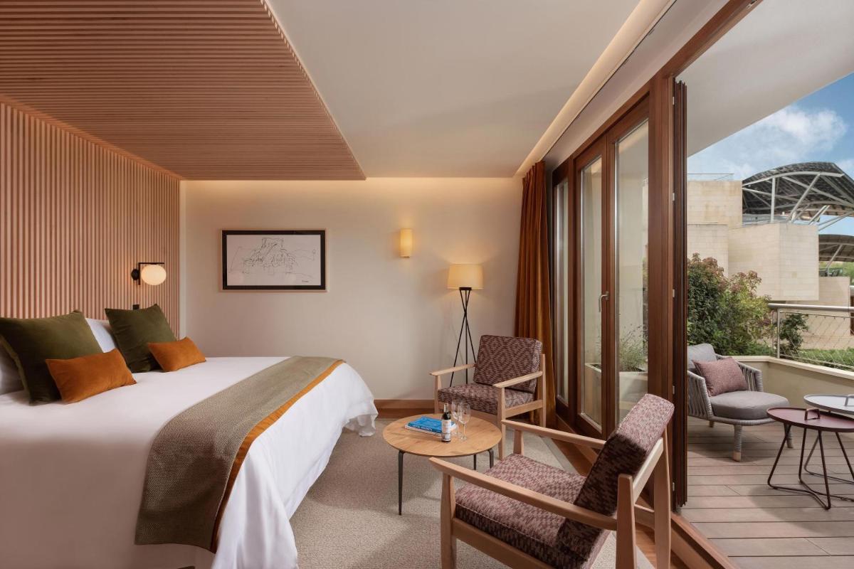 una habitación de hotel con una cama y un balcón en Hotel Marqués de Riscal, a Luxury Collection Hotel, Elciego, en Elciego