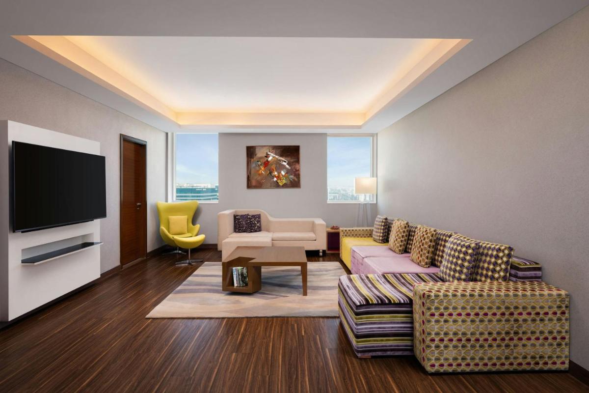 a living room with a couch and a tv at Aloft Bengaluru Outer Ring Road in Bengaluru