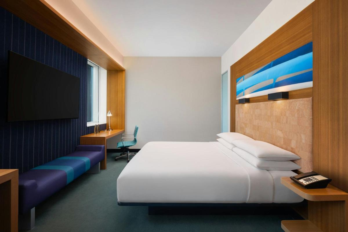 a hotel room with a bed and a flat screen tv at Aloft Bengaluru Outer Ring Road in Bengaluru
