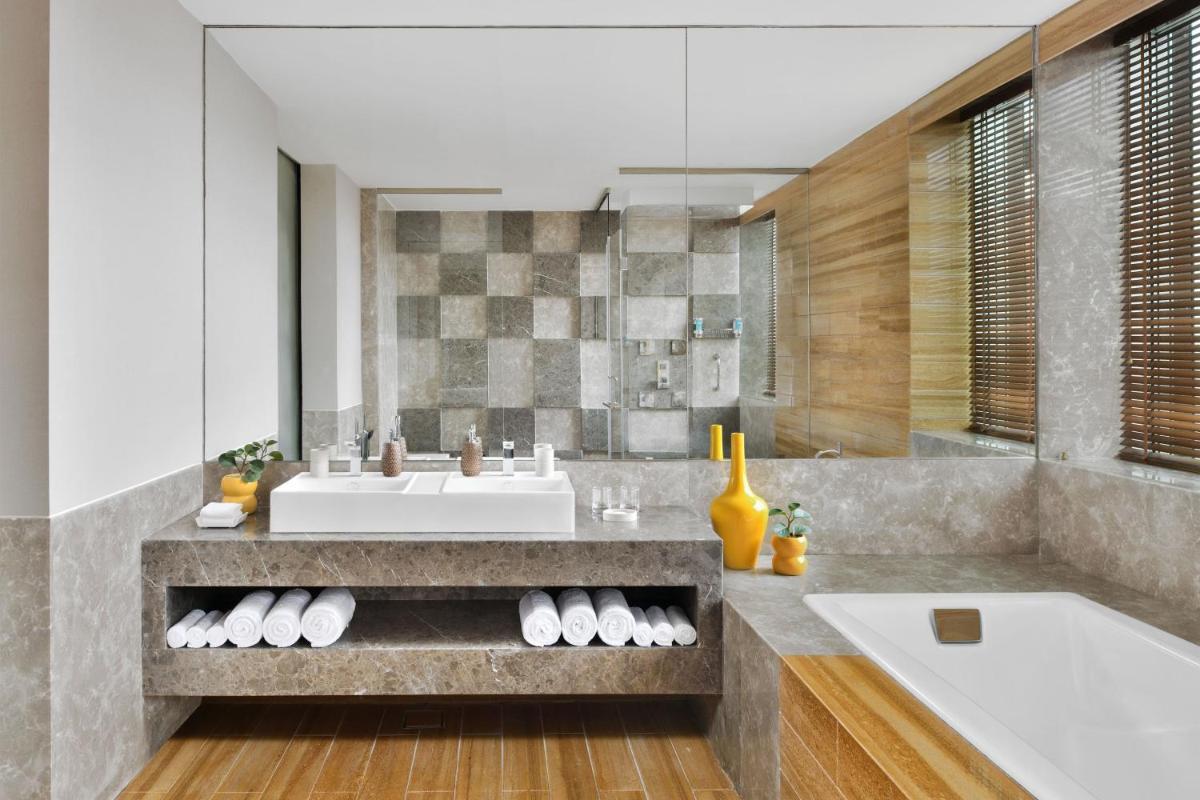 a bathroom with a sink and a bath tub at Aloft Bengaluru Outer Ring Road in Bengaluru