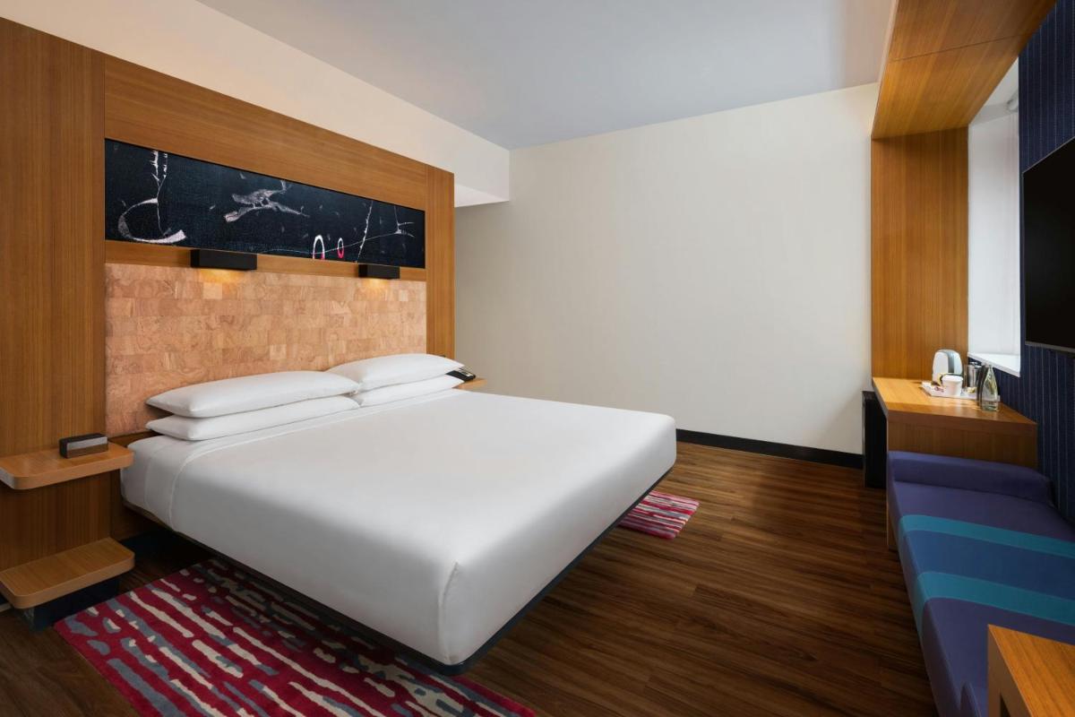 a bedroom with a large white bed in a room at Aloft Bengaluru Outer Ring Road in Bengaluru