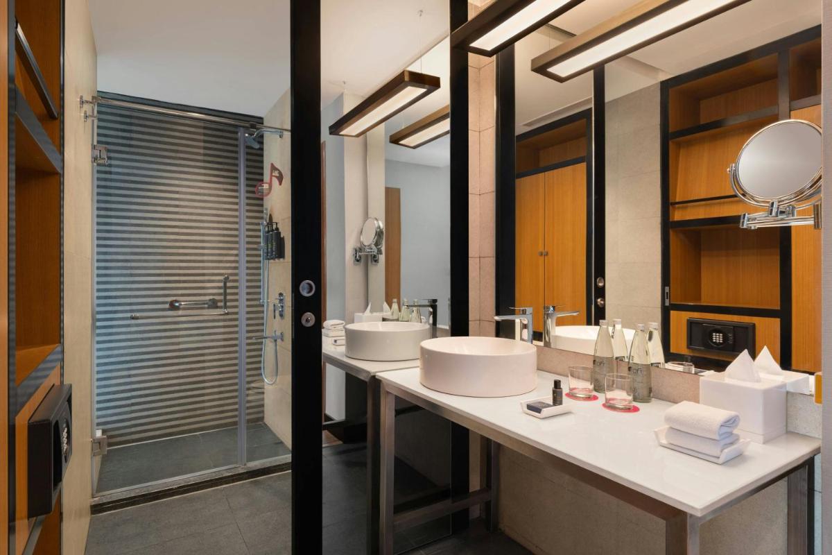 a bathroom with two sinks and a shower at Aloft Bengaluru Outer Ring Road in Bengaluru