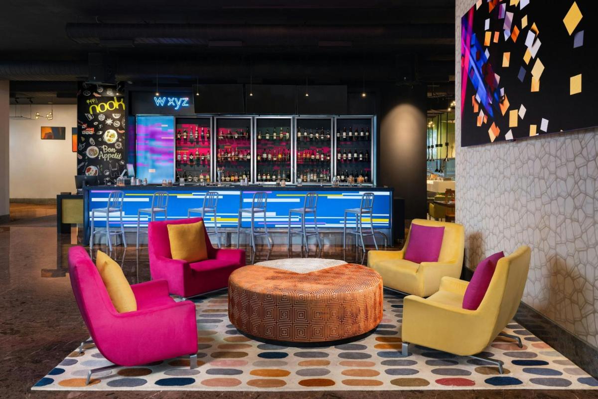 a group of chairs and a table in a bar at Aloft Bengaluru Outer Ring Road in Bengaluru