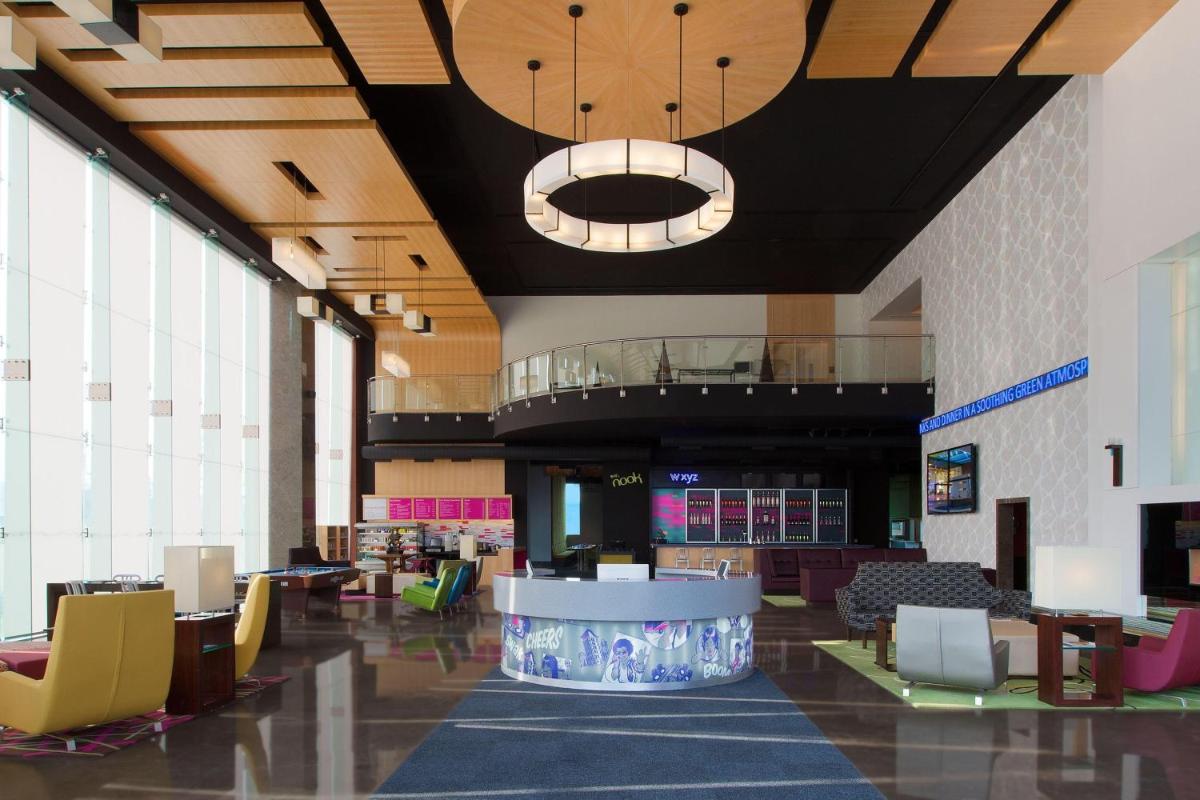 a lobby with a table and chairs in a building at Aloft Bengaluru Outer Ring Road in Bengaluru