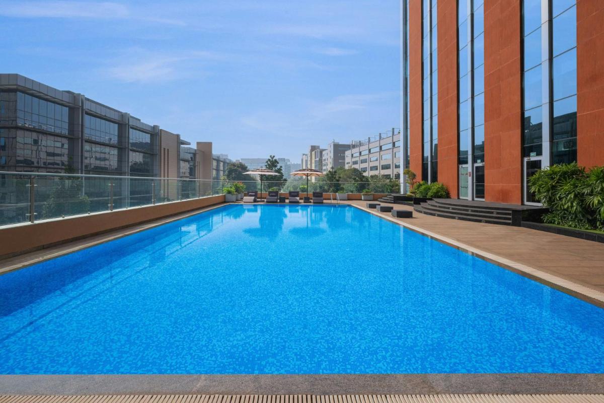 a large blue swimming pool on the roof of a building at Aloft Bengaluru Outer Ring Road in Bengaluru